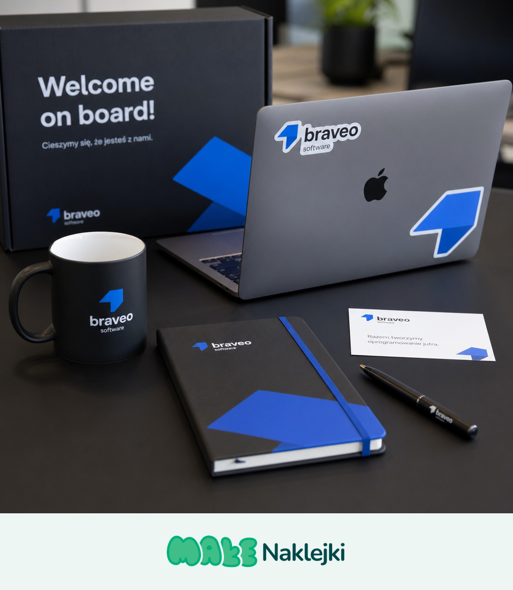 Zestaw powitalny (Welcome Pack) dla nowego pracownika - laptop, czarny kubek, notes i wizytówka oklejone spójnymi naklejkami firmowymi z logo na biurku.